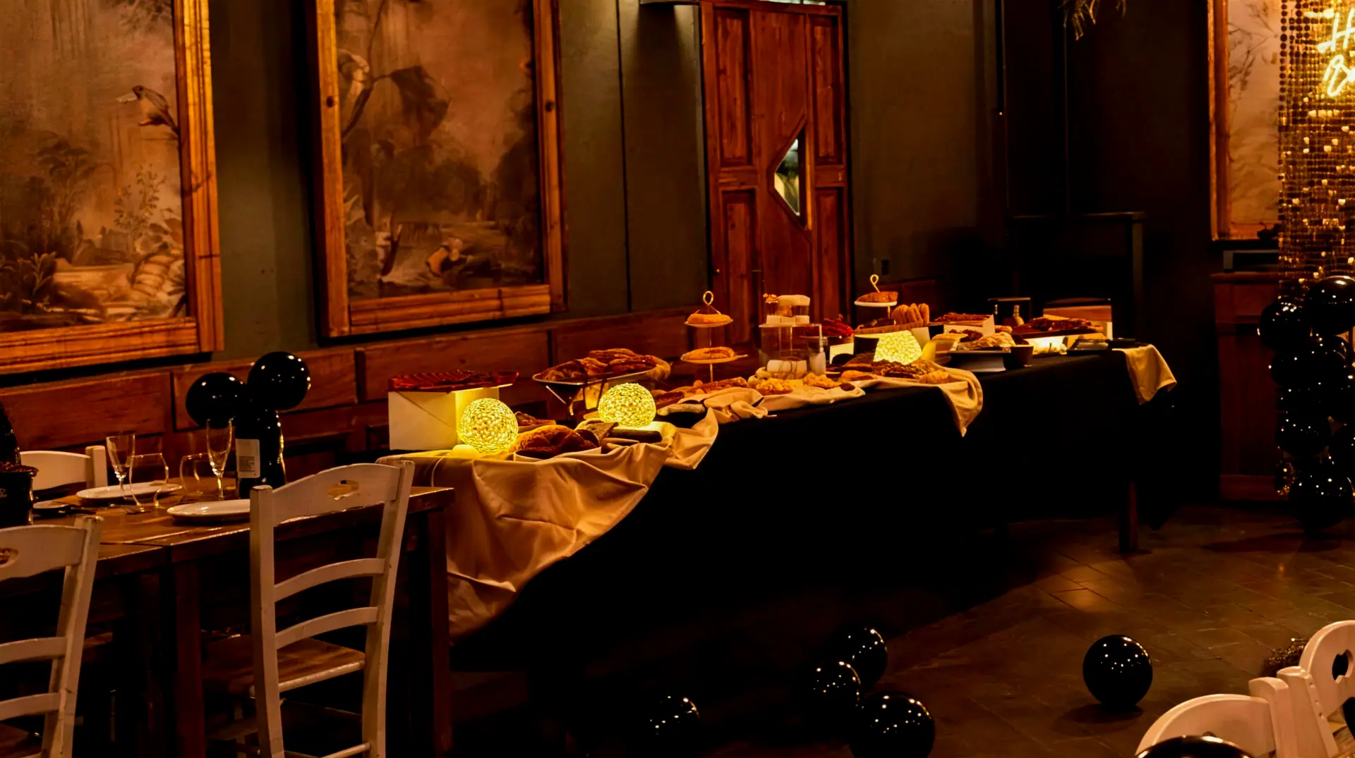 Il tavolo del buffet allestito nella sala rustica: vassoi di salumi e focacce, alzatine, taglieri e lampade di vimini accese